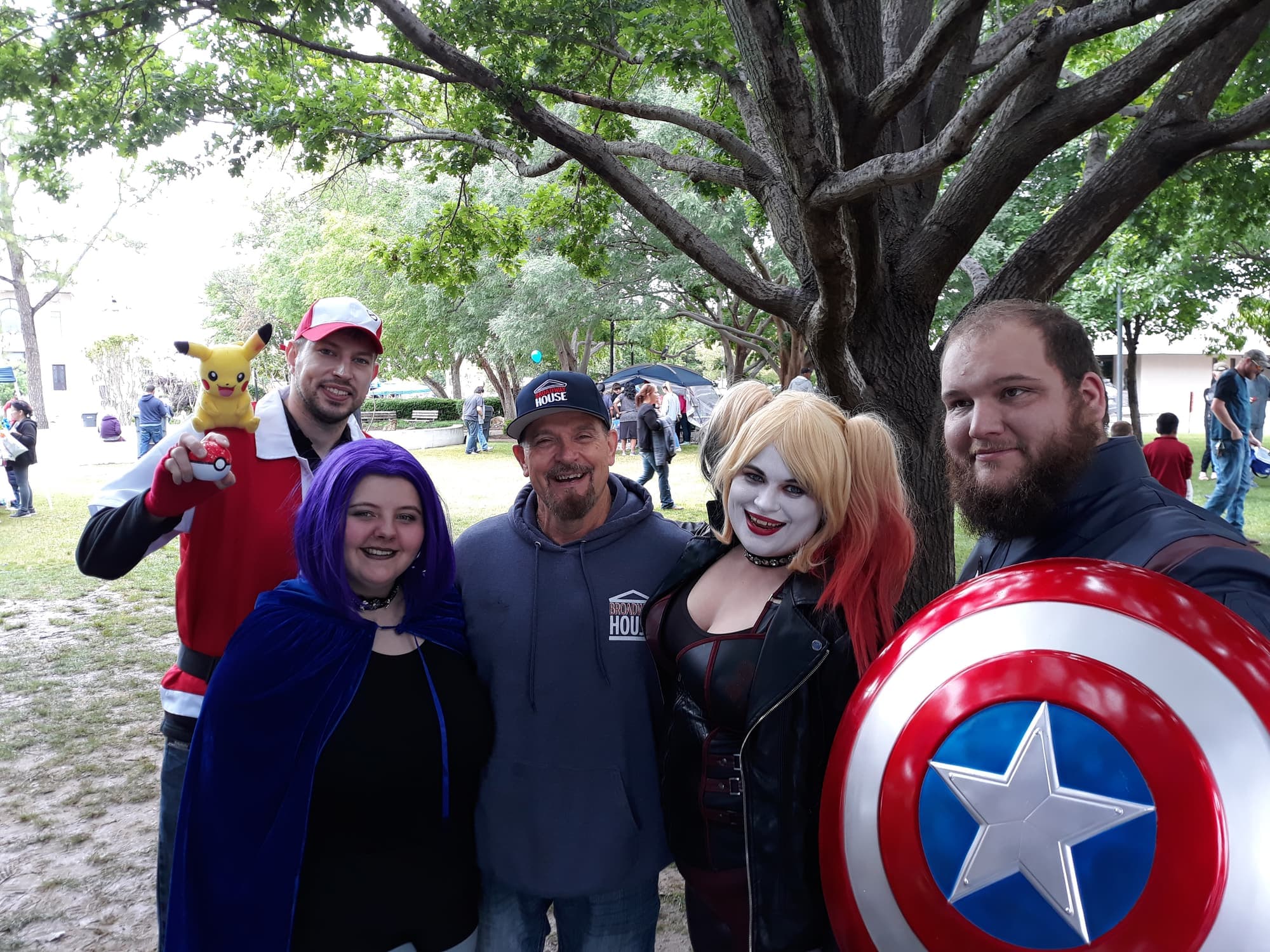 Volunteers dressed as superheroes and a Broadway House team member posing together